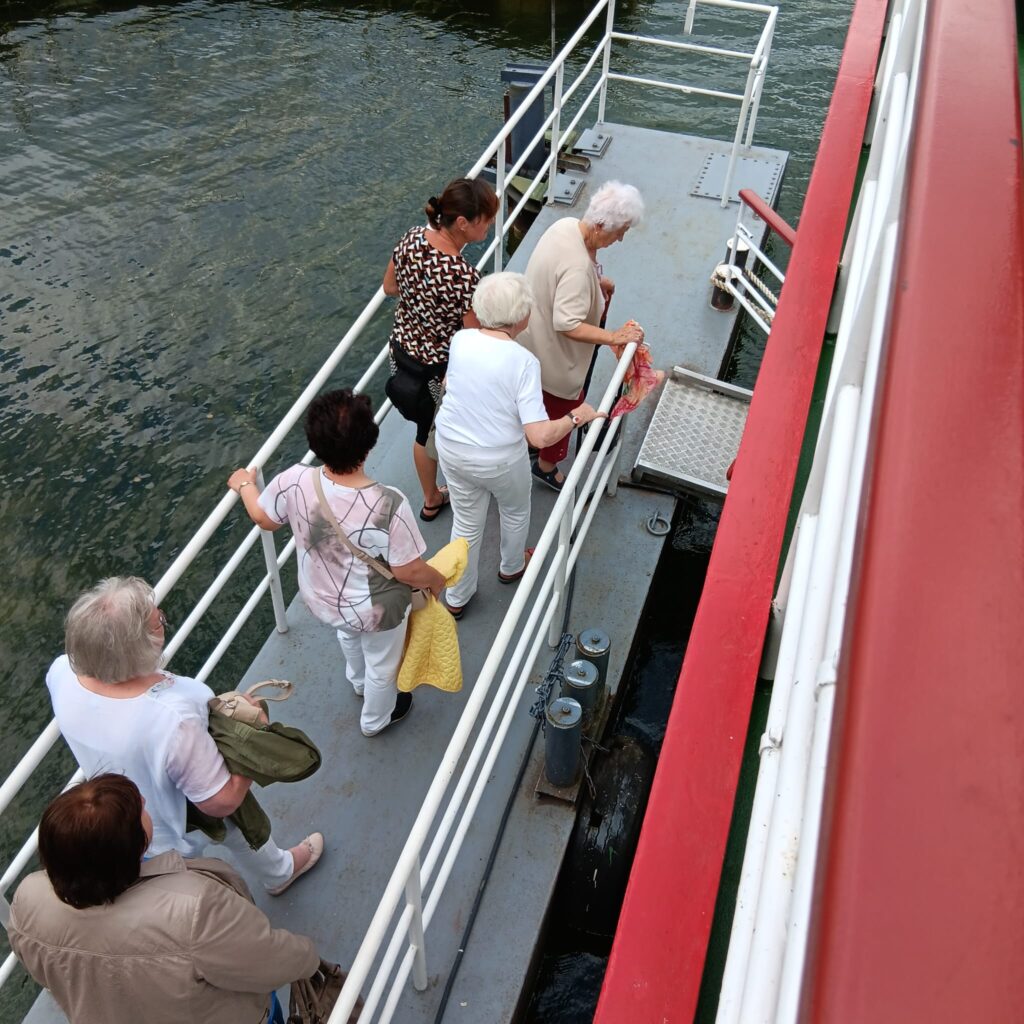 6 Frauen betreten ein Schiff über einen Steg