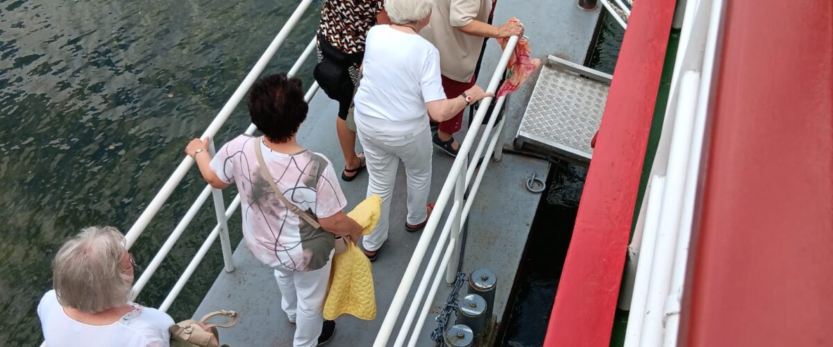 6 Frauen betreten ein Schiff über einen Steg