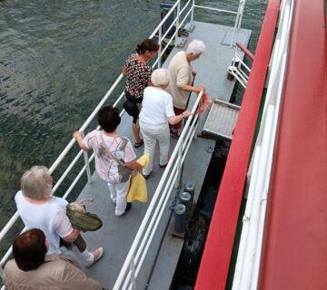 6 Frauen betreten ein Schiff über einen Steg