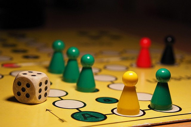 gesellschaftsspiel-7720875_640 Ausschnitt eines Mensch-ärgere-dich-nicht Spielbretts mit Figuren und einem Würfel