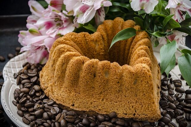 kuchen Ein Topfkuchen in Herzform steht auf einem Teller mit Kaffeebohnen