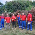 Gruppenfoto. 5 Männer und eine Frau stehen auf einer Wiese.
