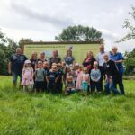 Eine Gruppe von Kindern und Erwachsenen auf der Streuobstwiese