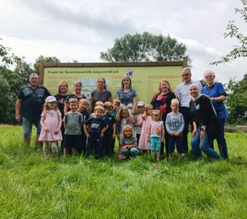 Eine Gruppe von Kindern und Erwachsenen auf der Streuobstwiese