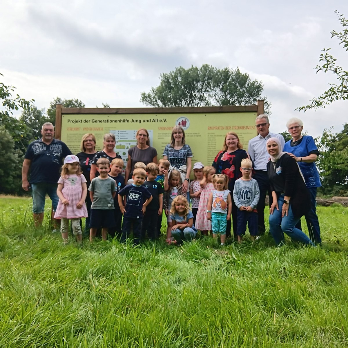 Eine Gruppe von Kindern und Erwachsenen auf der Streuobstwiese