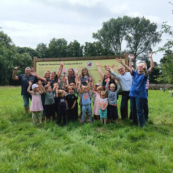 Eine Gruppe von Kindern und Erwachsenen auf der Streuobstwiese und jubeln